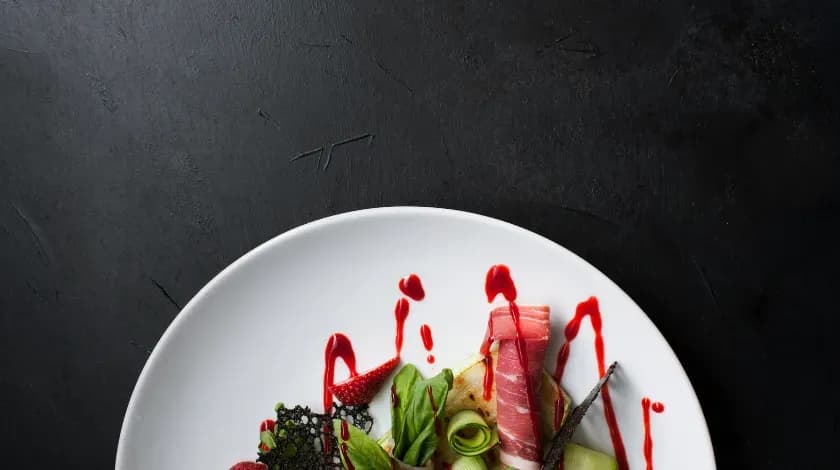 黒い皿に盛り付けられた料理の写真